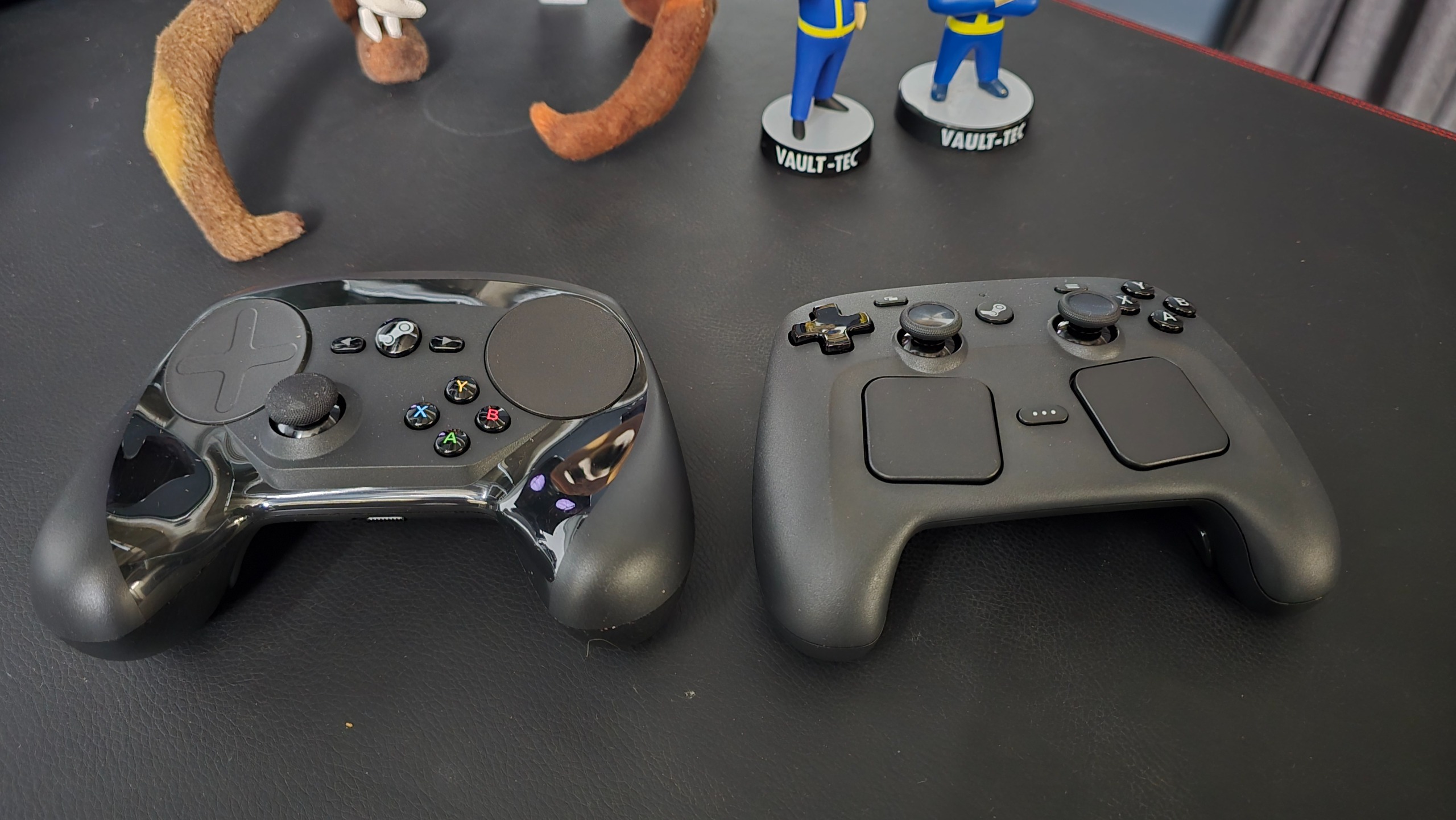 Two Steam Controllers on a black desk