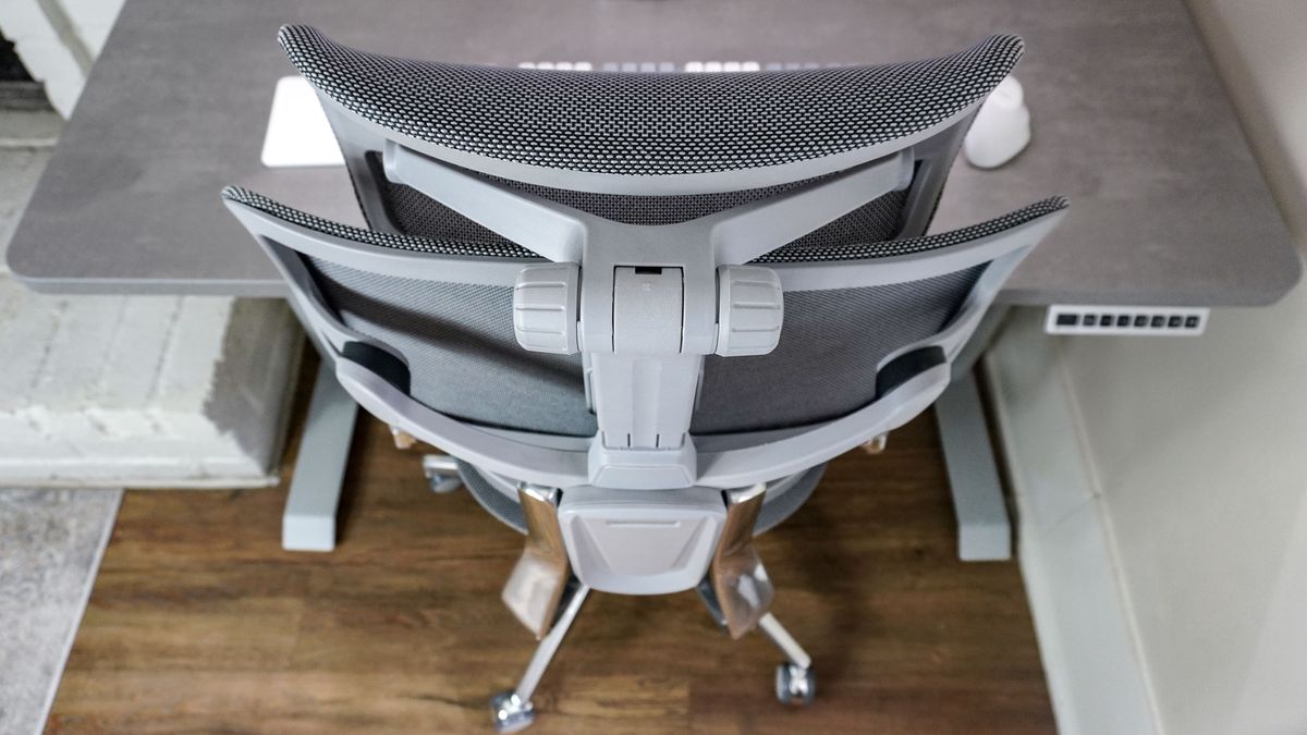 The Hinomi X1 ergonomic office chair pushed into the Hinomi S1 electric standing desk