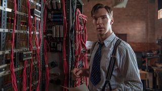Benedict Cumberbatch stands next to the Bombe machine in The Imitation Game