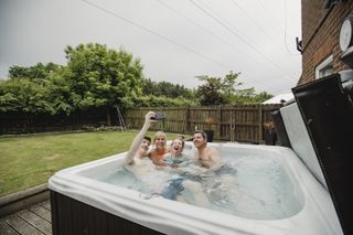 Family taking selfie while in hot tub at home