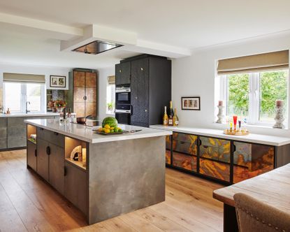 Wood kitchen flooring in a white scheme with dark stone cabinetry and a kitchen island.