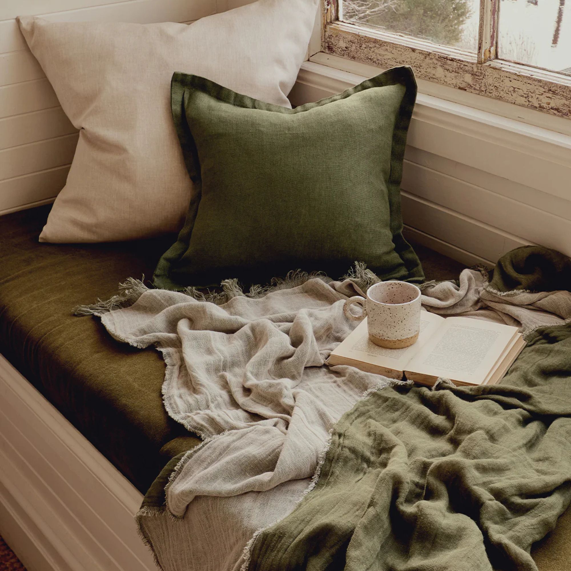 Oatmeal & Olive Muslin Throw on a bench. 