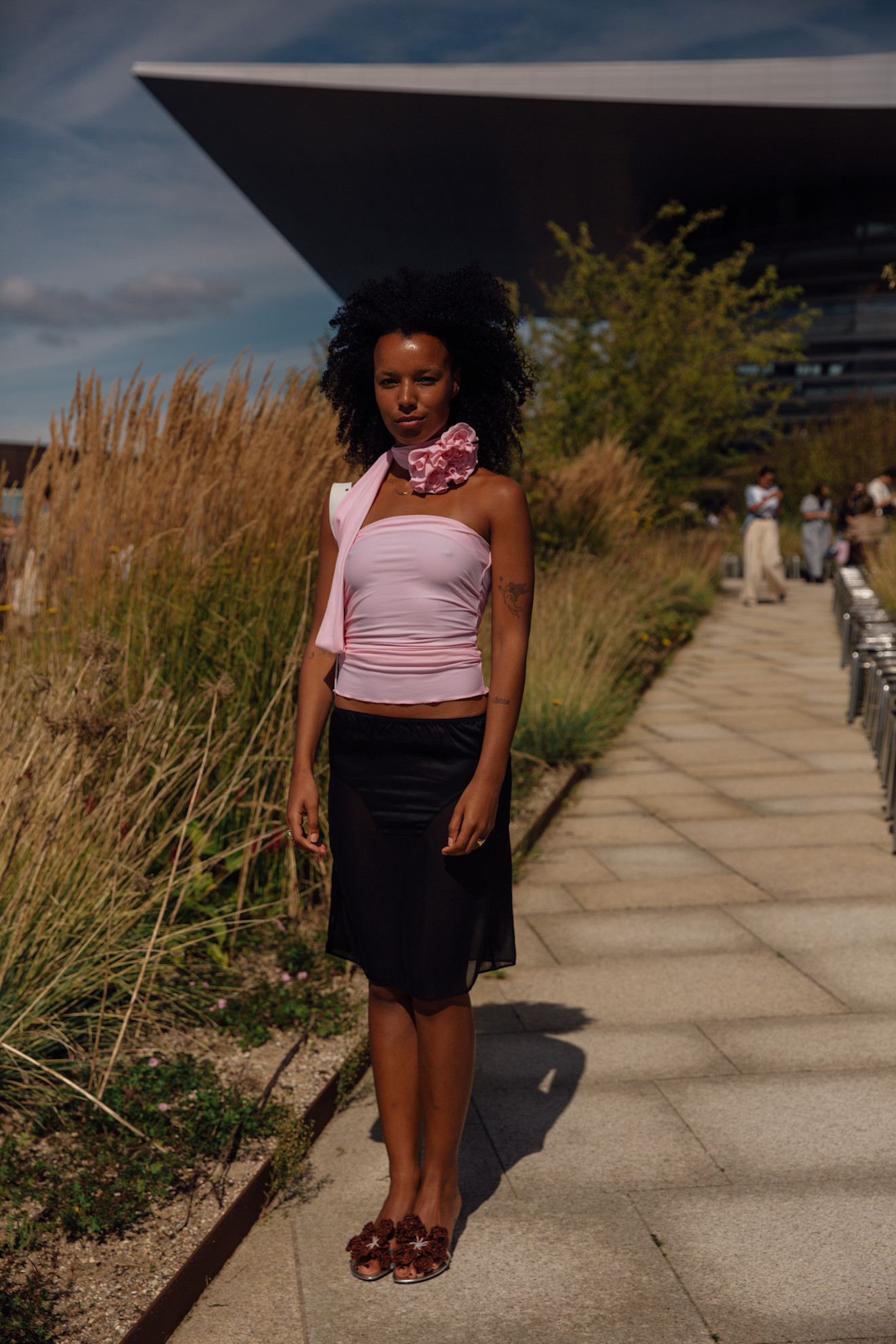woman wearing a pink top and a black knee-length skirt