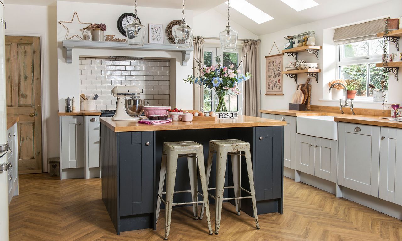 White kitchen with grey kitchen island, industrial bar stools, butler sink, wood worktops and open shelving