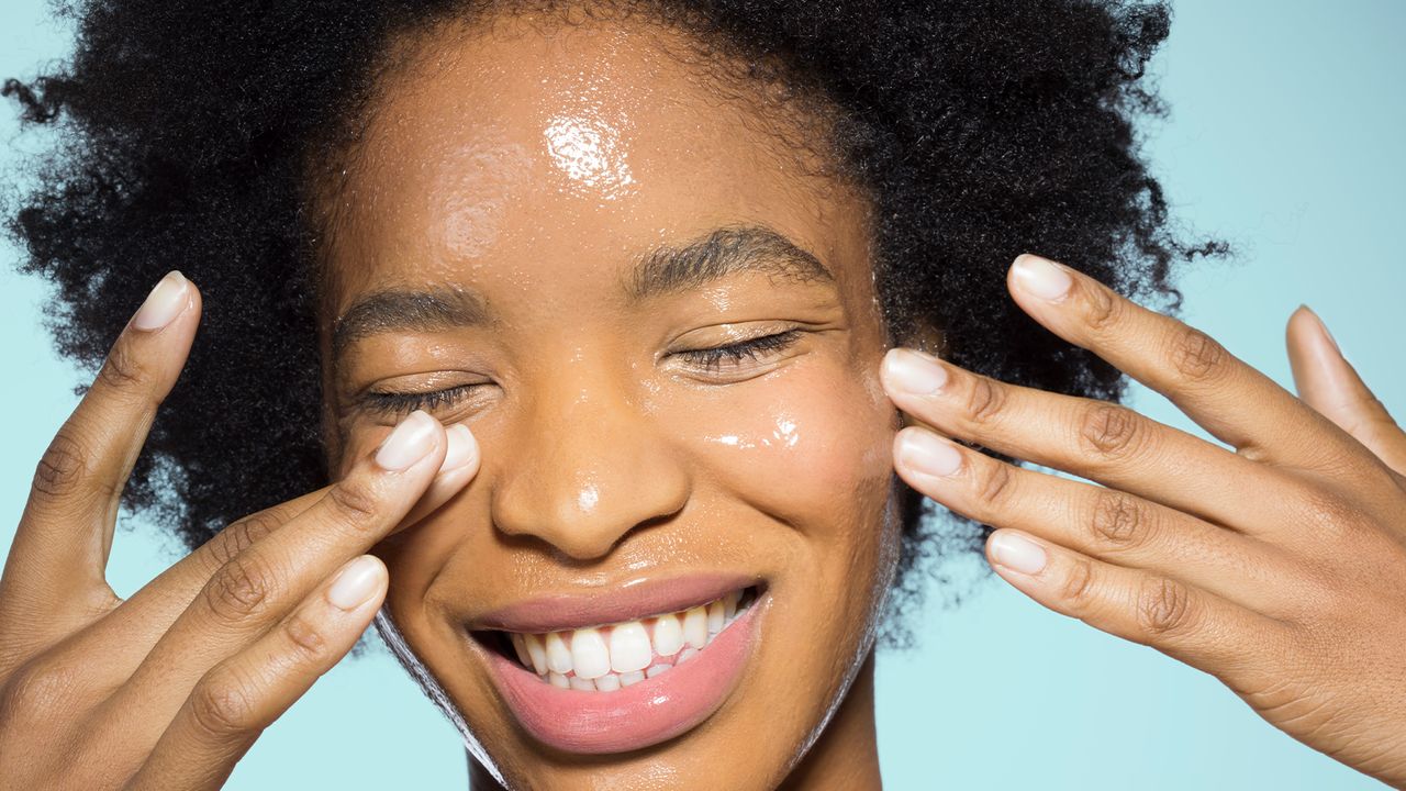 Young female applying glossy make-up - stock photo