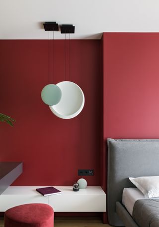 Red walls and grey furnishings in the bedroom