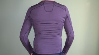 A purple Maap Thermal LS base layer as seen from behind being worn by a man. Seams travel across the shoulders and around the nape of the neck