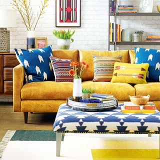 Living room with ochre sofa, patterned ottoman and rug