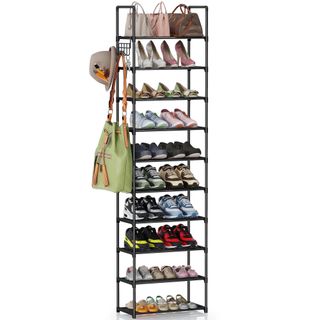 A black vertical shoe storage shelf with shoes, bags and hats