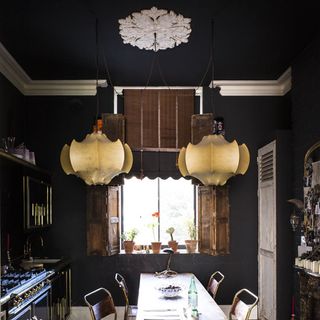dining room with ceiling lamps and dark walls