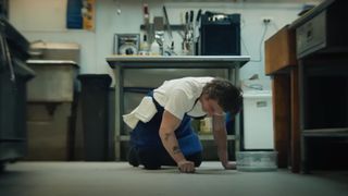 Jeremy Allen White as Carmen "Carmy" Berzatto, scrubbing the floors during the Hulu show, The Bear.