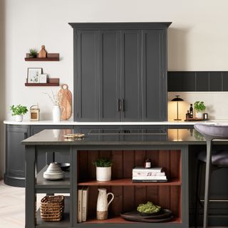 dark grey kitchen with island with hob and shelving