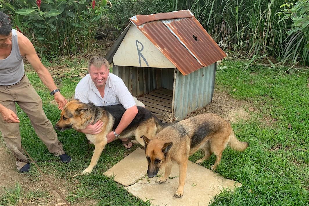 Meteorite collector Michael Farmer seen in front of Rocky's doghouse, Rocky and a second dog.