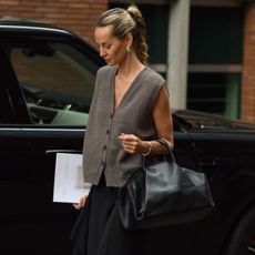 Woman wears grey sleeveless knit, black skirt, black Fold tote