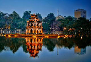 A pagoda on the Hoàn Kiếm Lake in Hanoi lit up at night