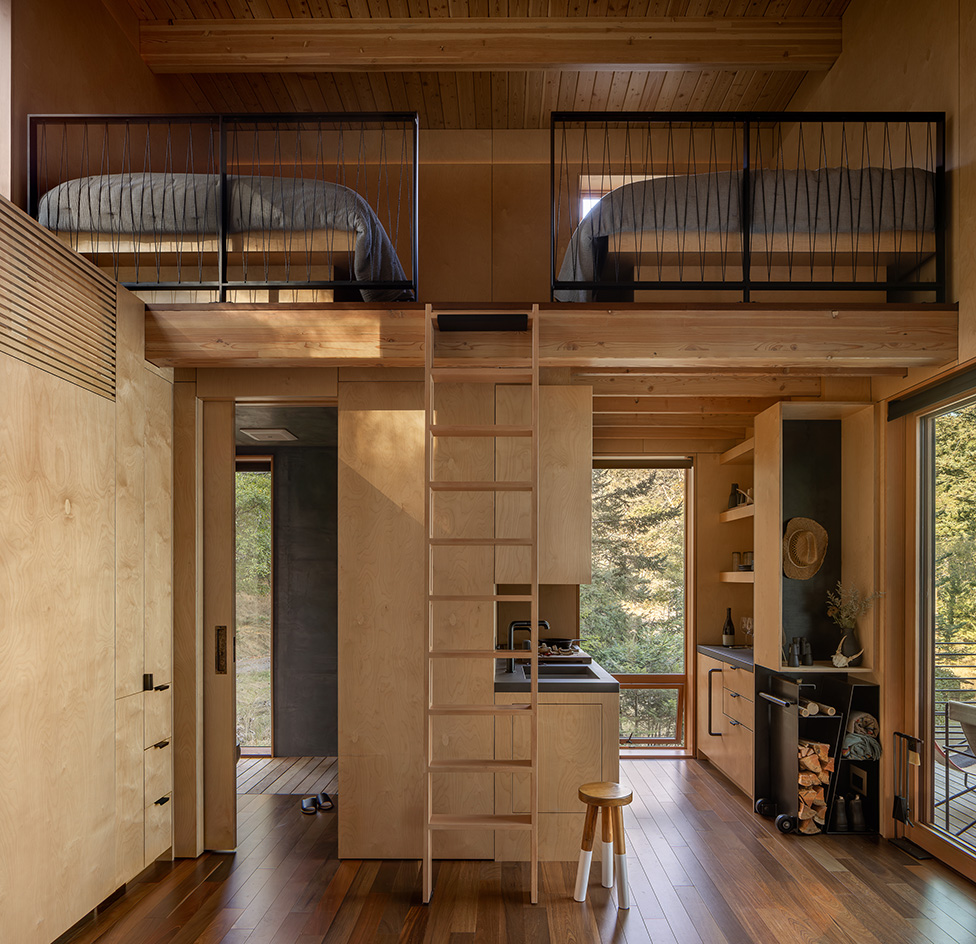 Blakely Island Cabin, a boxy structure raised on stilts above tree canopy in washington state forest