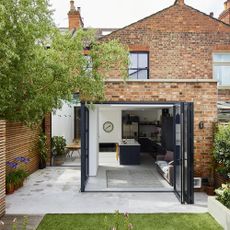 Facebrick house with bifold doors next to lawn