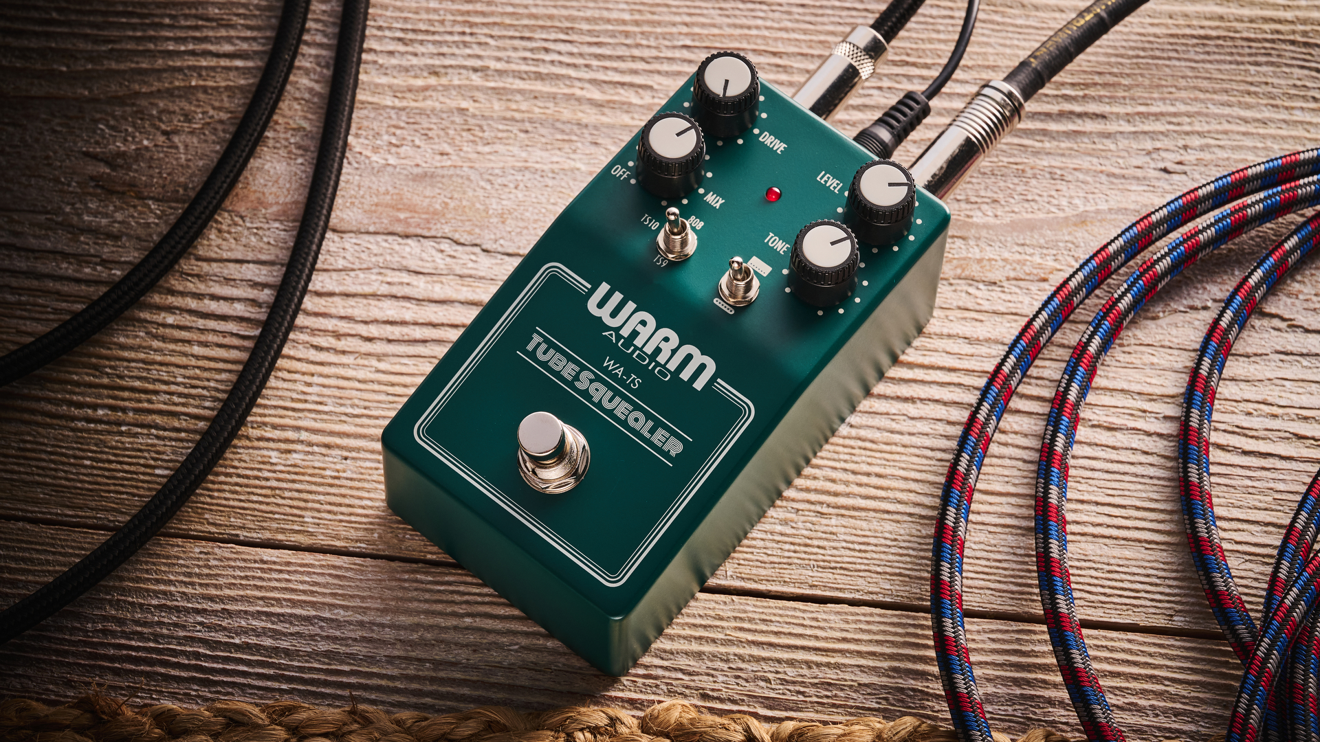 Warm Audio Tube Squealer green overdrive pedal shot on wood floorboards