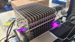 The Noctua NH-P1 air cooler mounted on an open-bed test bench with pink RGB lighting
