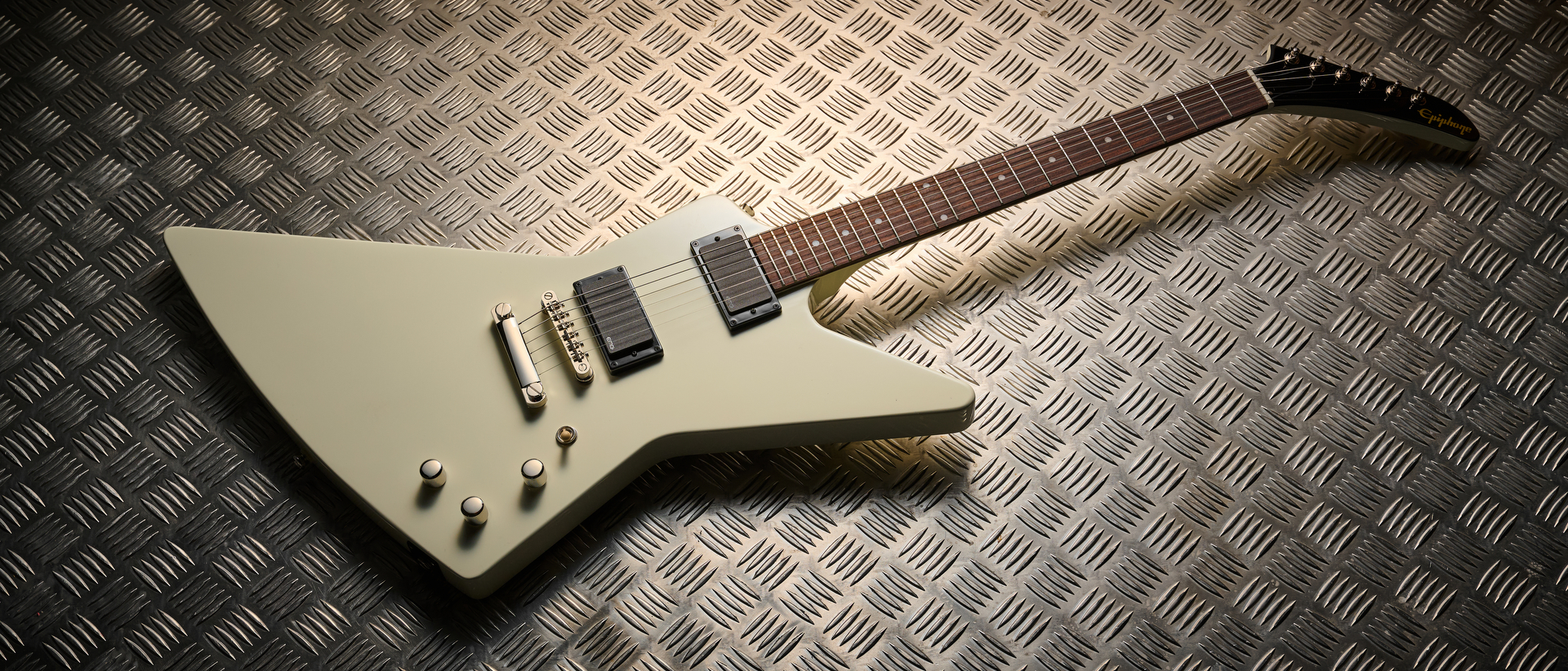 An Epiphone Explorer 80s EMG lying on some sheet metal