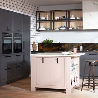 black and white kitchen with built-in ovens and pastel pink cabinet
