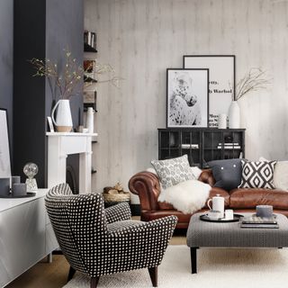 Cosy living room with chimney breast painted dark grey and light panel-effect wallpaper behind a leather chesterfield sofa