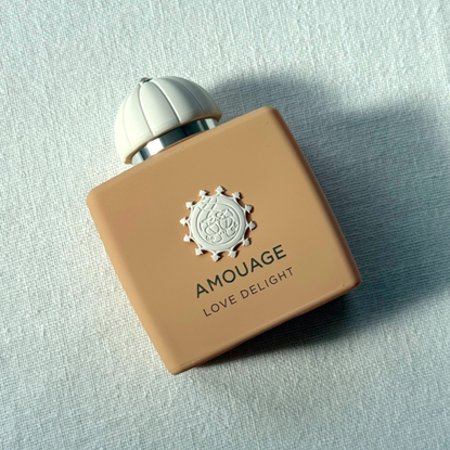 Bird's eye view of Amouage Love Delight Eau de Parfum against a white linen background