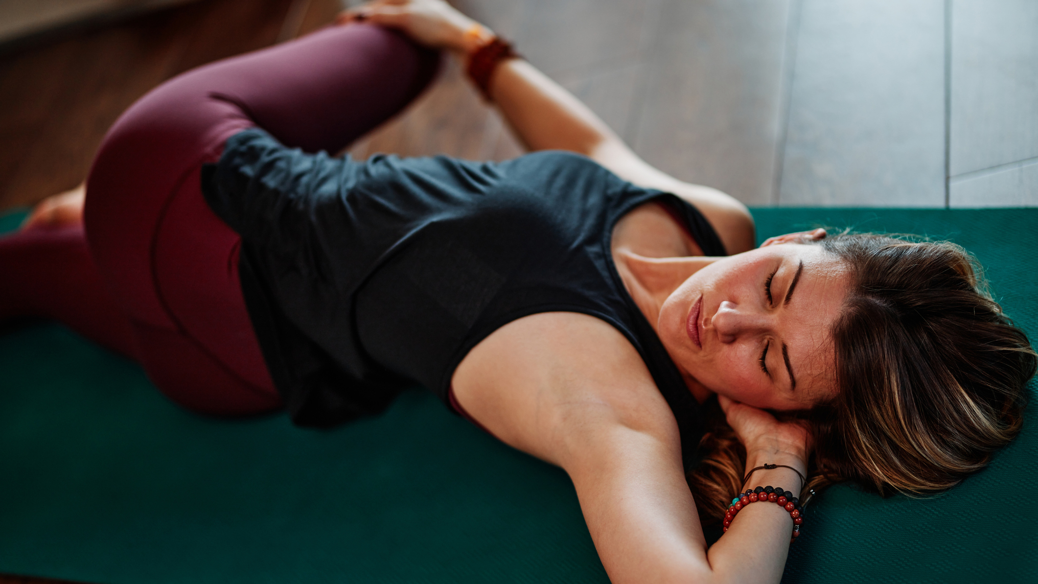 Woman lying on a mat stretching