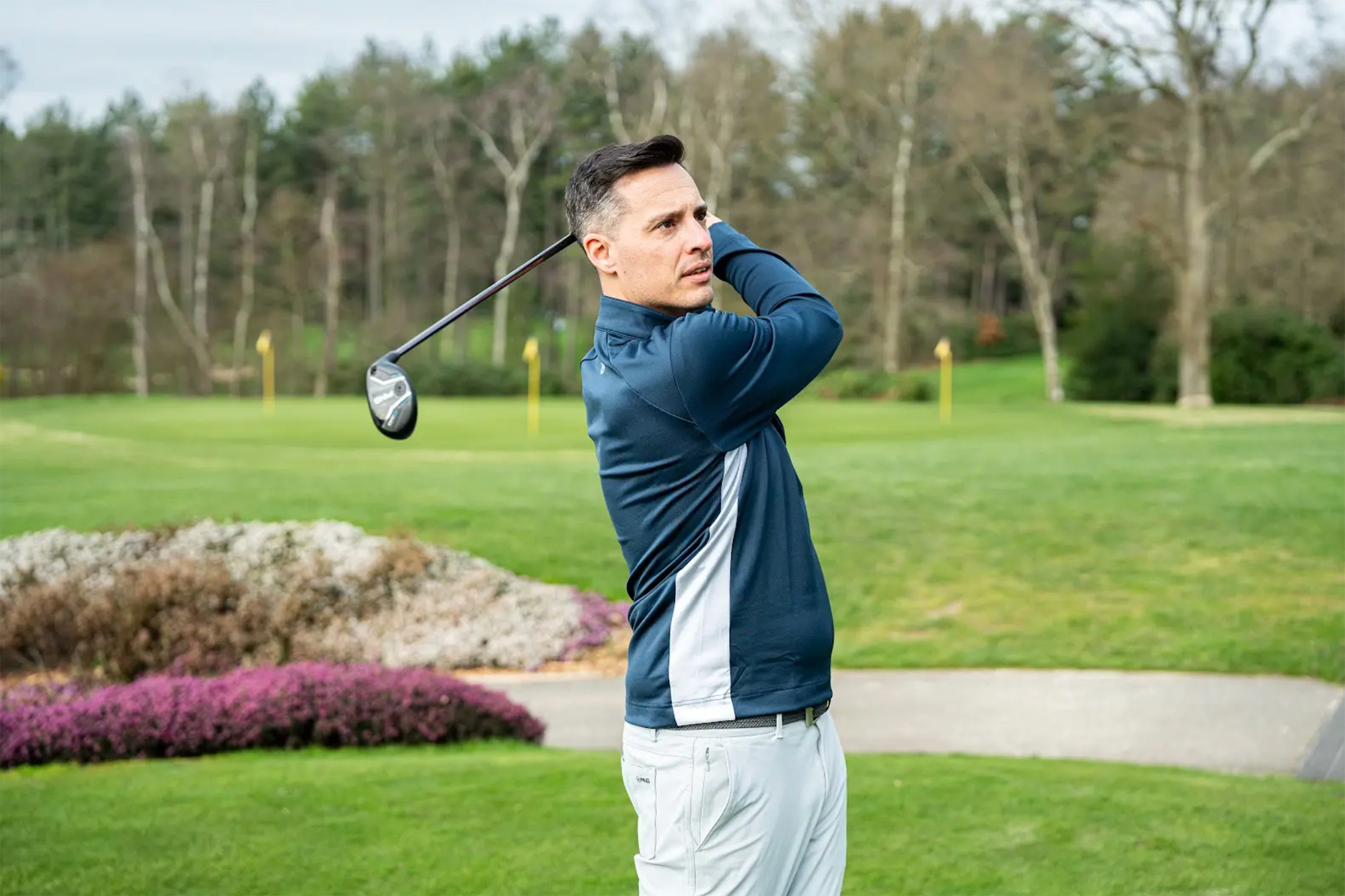 Joel Tadman in the finish position of the golf swing after hitting a hybrid instead of a long iron in accordance with Shot Scope data suggesting that improves GIR percentages