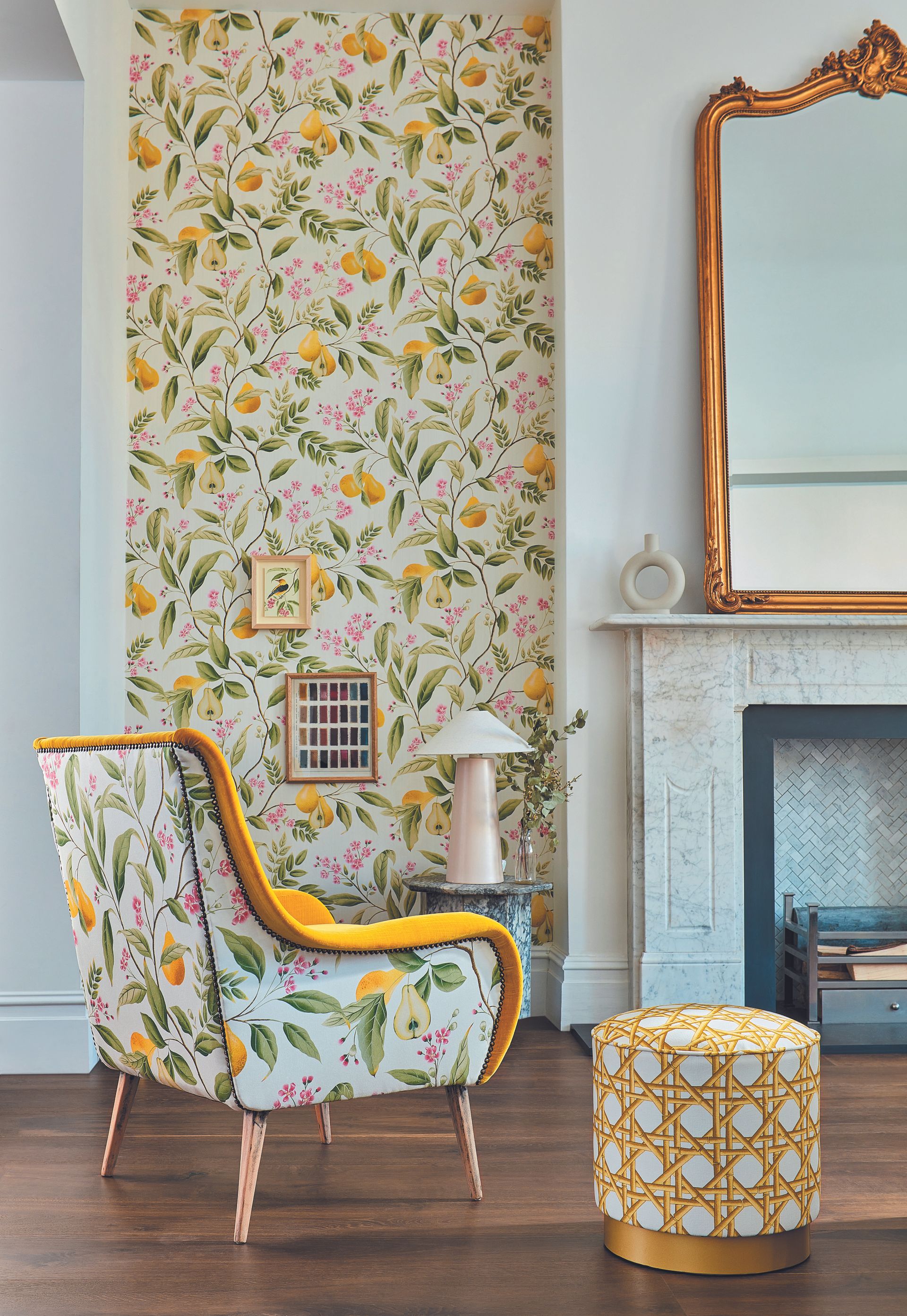 living room with floral wallpaper with lemons, matching armchair, fireplace, mirror