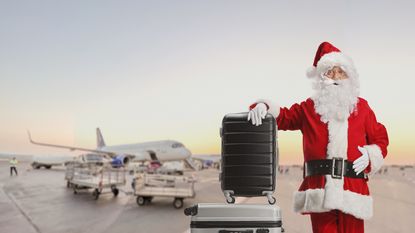 Santa stands with his bag near an airplane.
