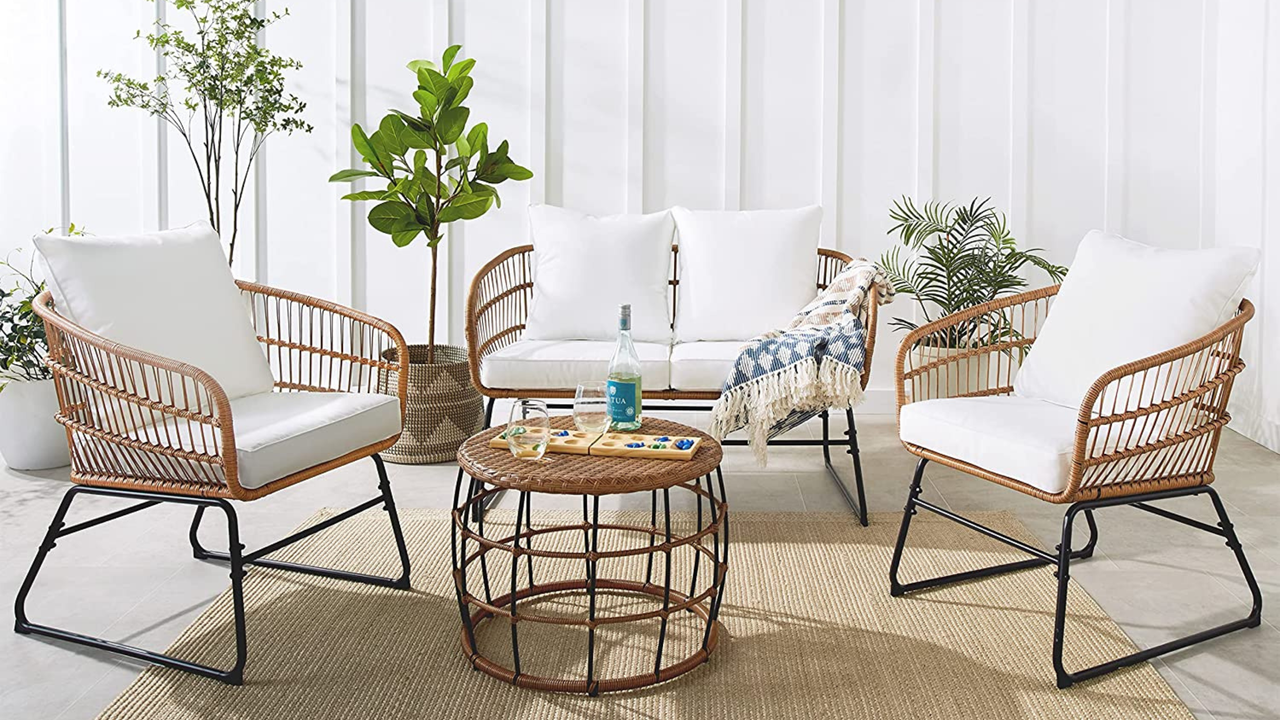 A wicker seating set with a coffee table on a rug. 