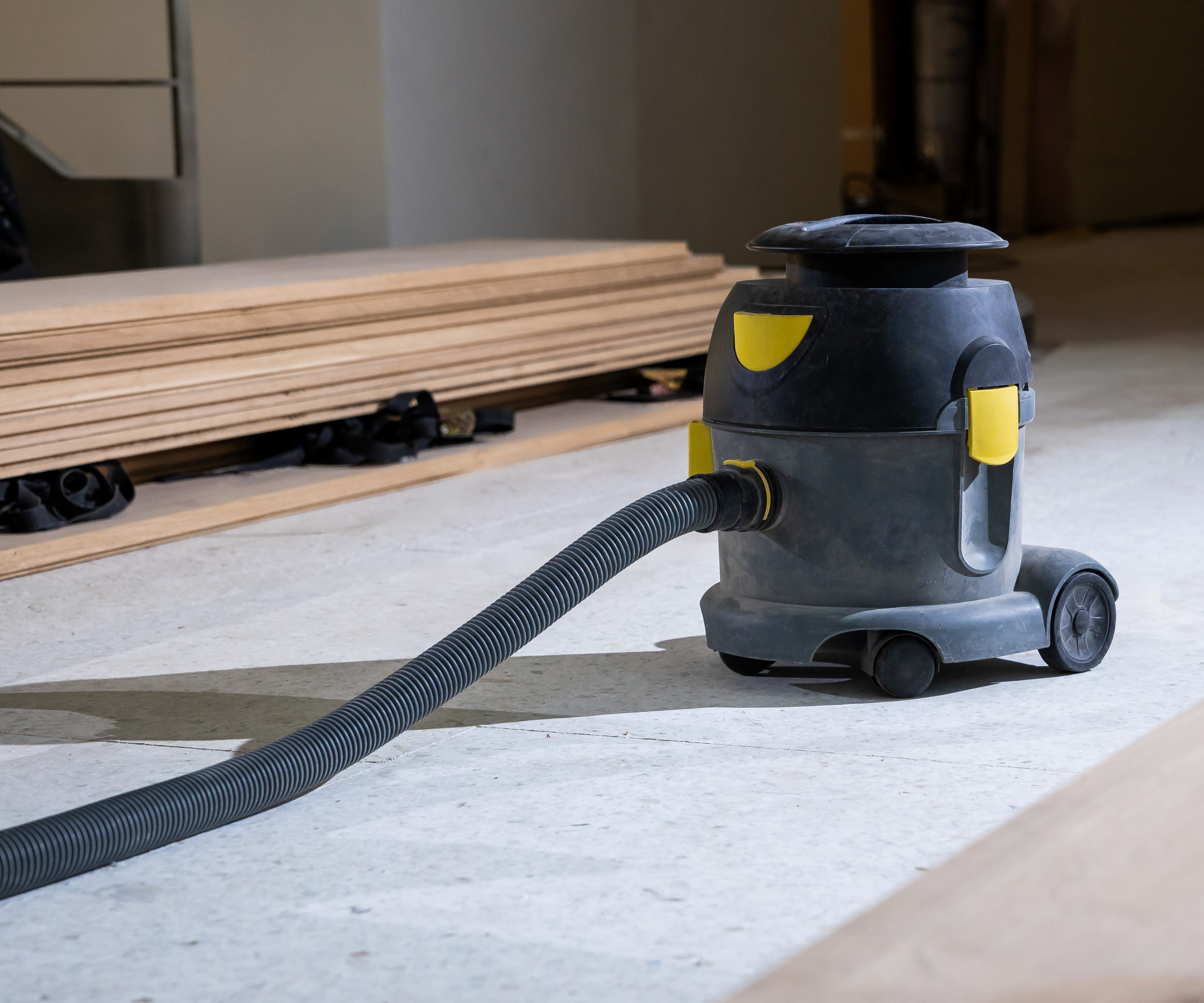 Vacuum cleaner with wooden planks in the background
