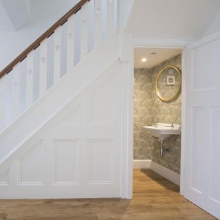 hallway with white walls wooden flooring and stairs