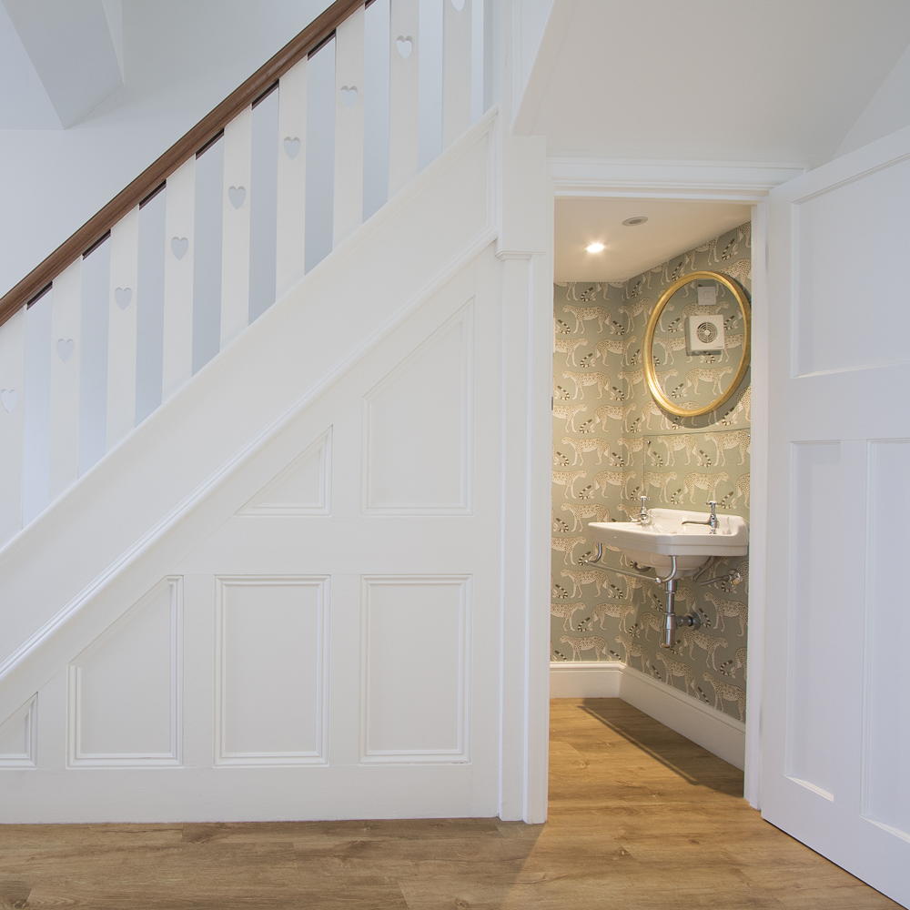 hallway with white walls wooden flooring and stairs