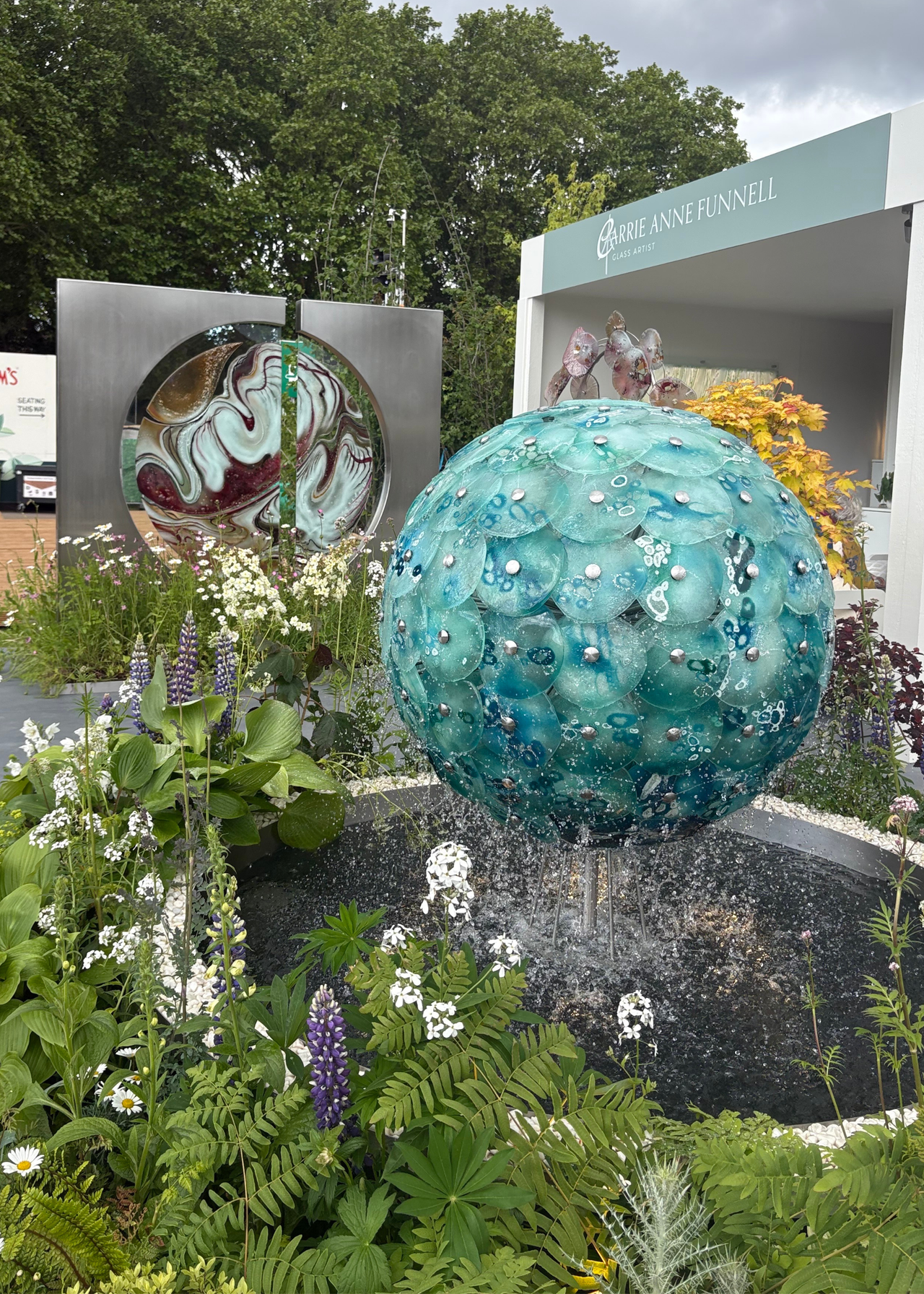 A colorful glass sculpture water feature at the Chelsea Flower Show 2026