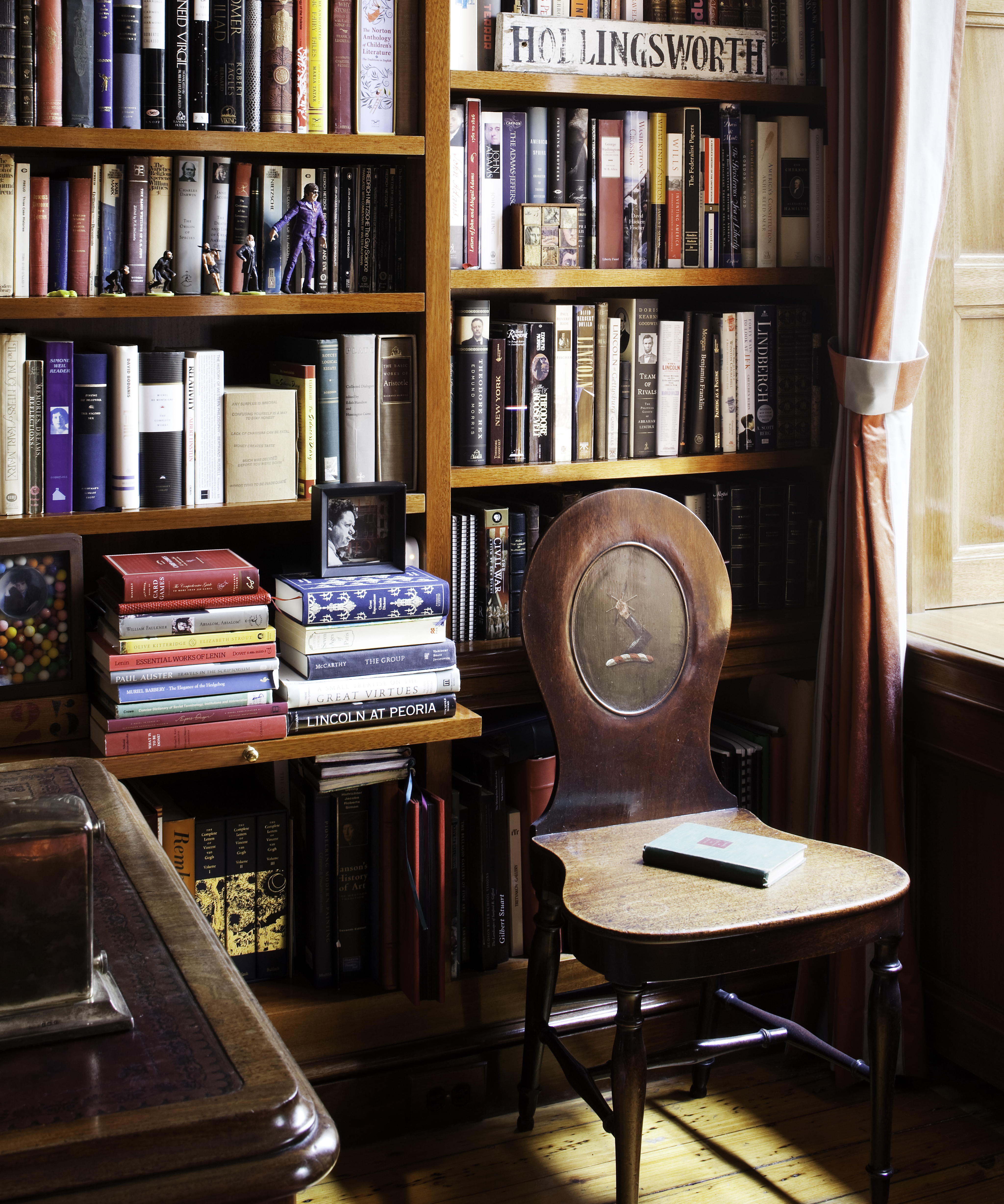 antique wood chair in front of a bookshelf full of books
