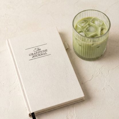 gratitude journal and an iced matcha in a glass
