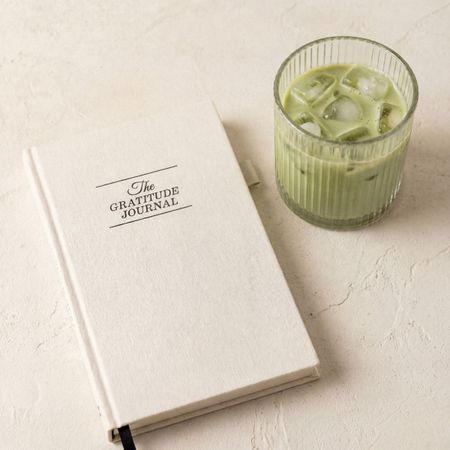 gratitude journal and an iced matcha in a glass