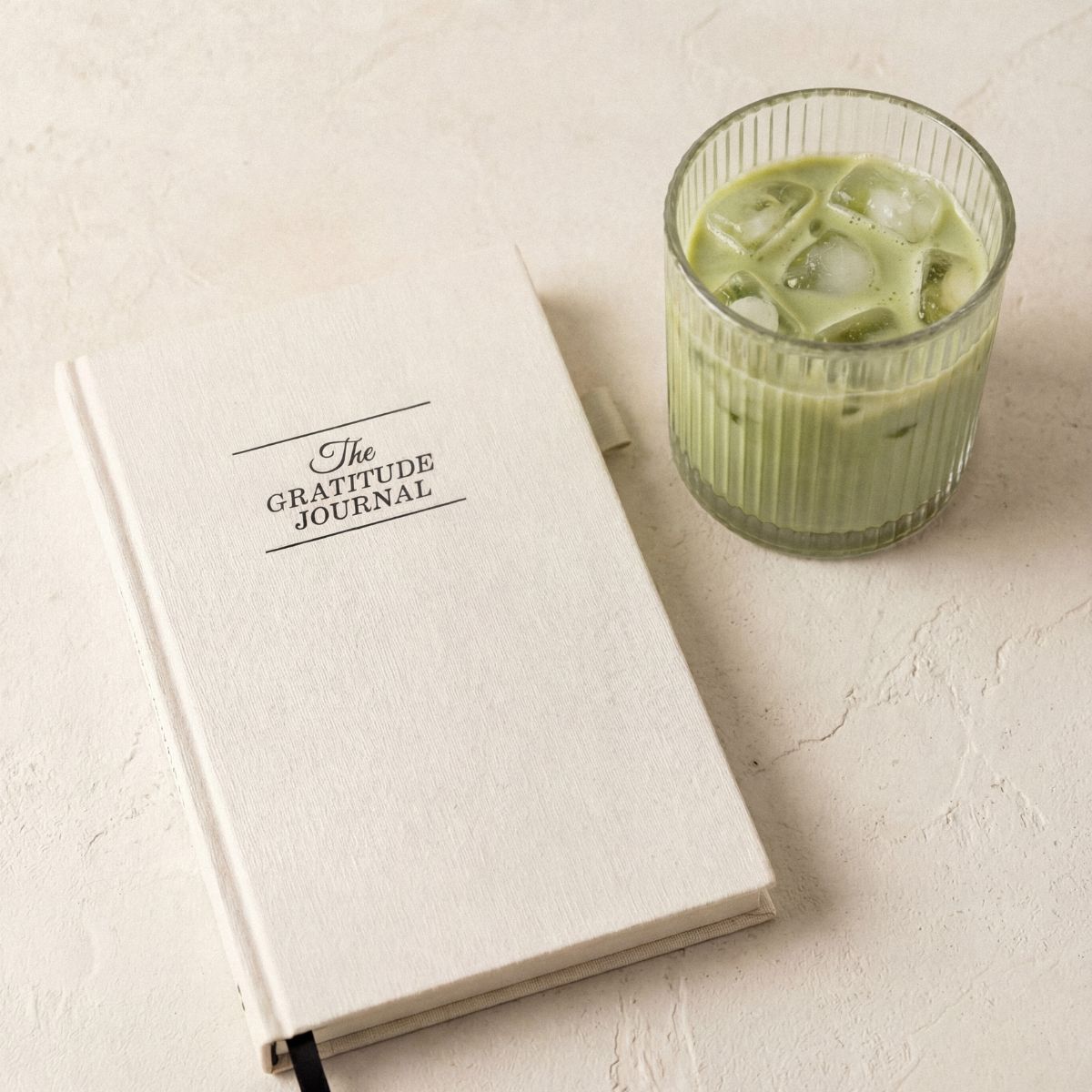 gratitude journal and an iced matcha in a glass