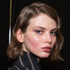 a model's very glowy face backstage at a fashion show - best essences