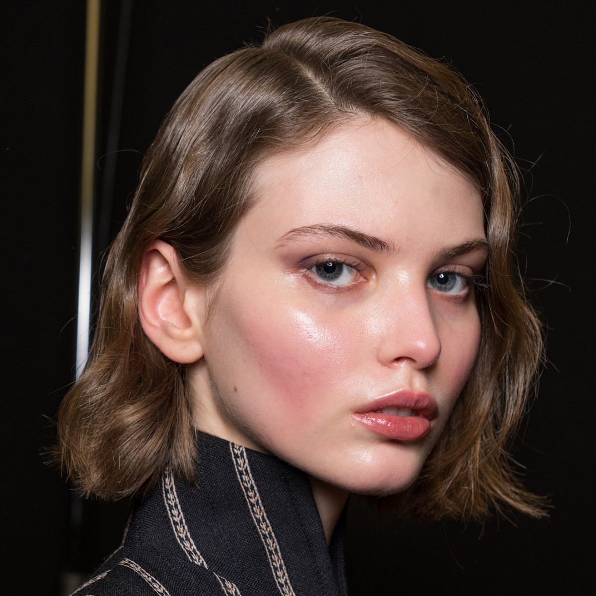 a model's very glowy face backstage at a fashion show - best essences