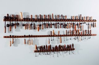 Tools hang on wooden shelves against a wall