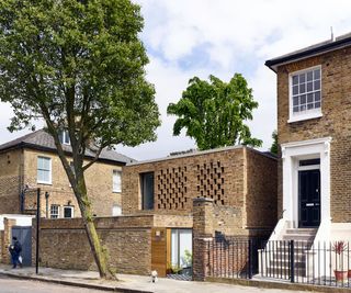 garage conversion on residential street with brick facade and a light and airy interior with split level living and kitchen diner space