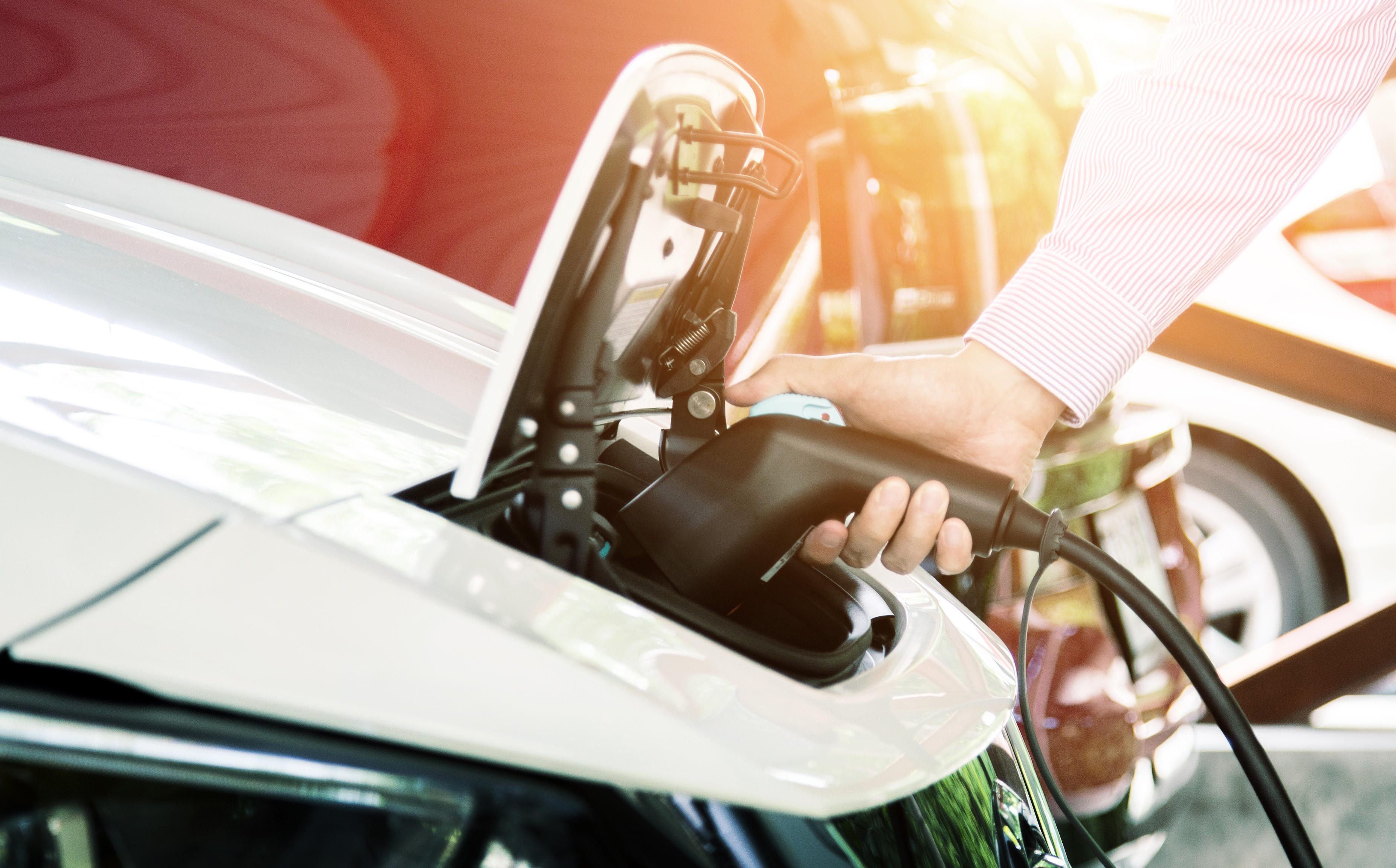a guide to ev chargers with a man charging his white car