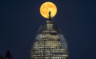 The "blue moon" full moon of July 31, 2015 rises behind the dome the U.S. Capitol in this image from NASA photographer Bill Ingalls. The May 21, 2016 full moon is the fourth full moon in spring, which is also known as a "blue moon."