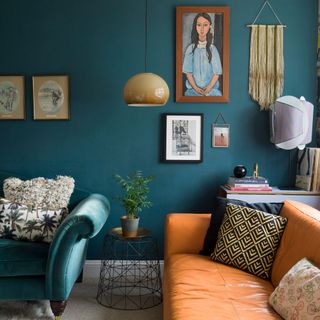 teal living room with teal velvet sofa tan leather sofa and gallery wall with artwork and wall hangings
