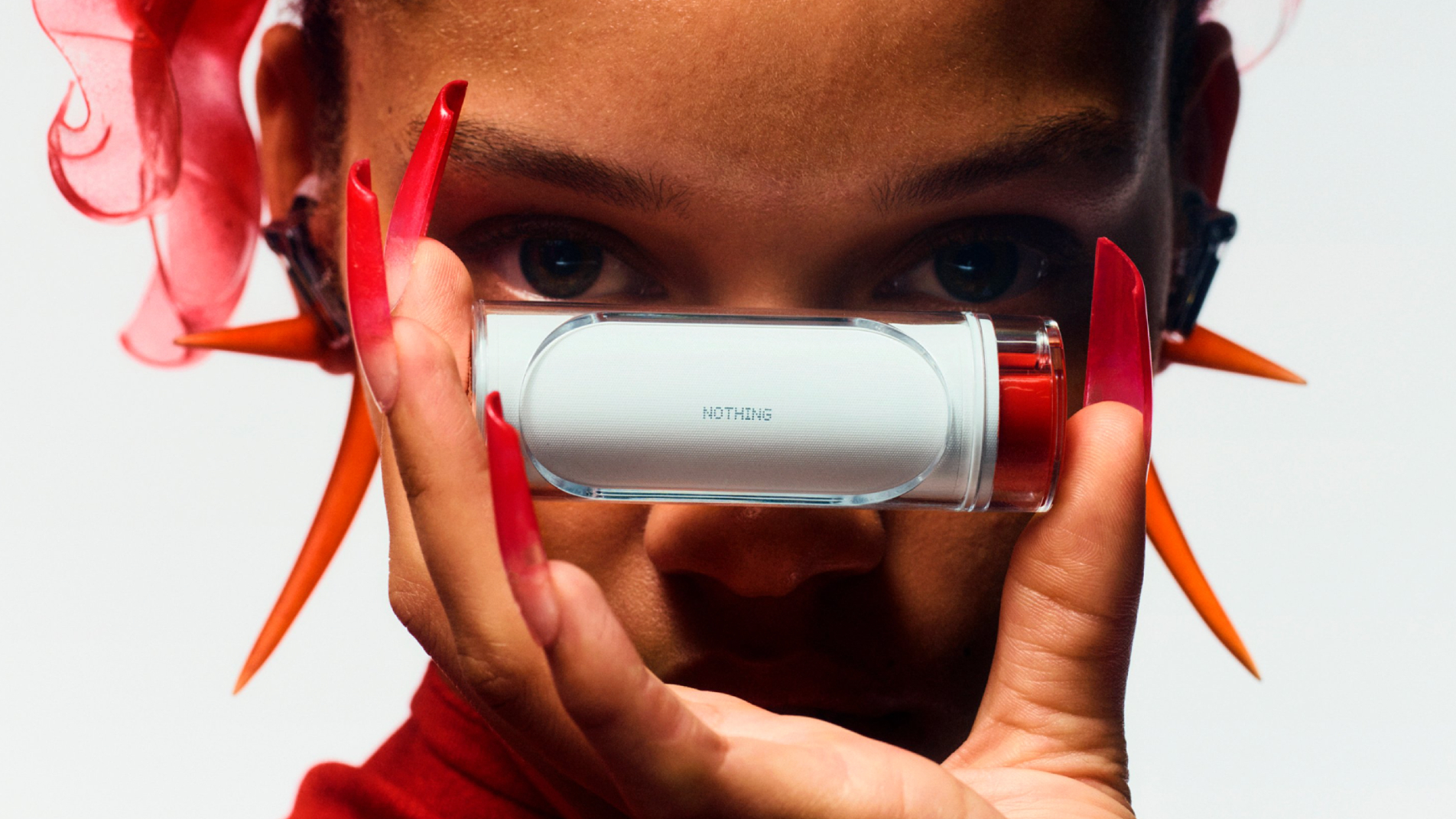 Nothing Ear (stick) earbuds case, held in front of a model's face