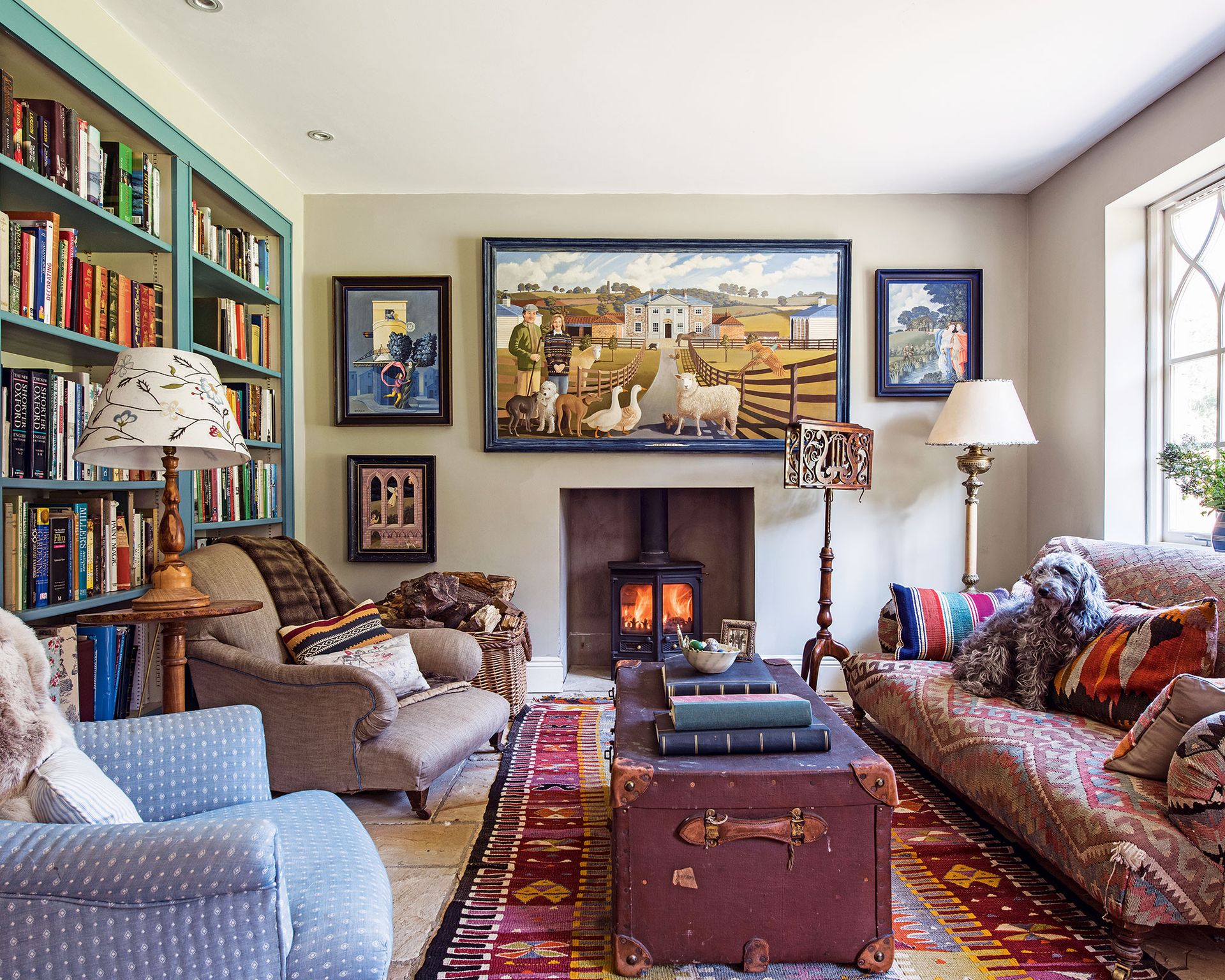 How to design a living room color palette with green bookshelves, blue and brown armchairs and red patterned rug and armchair.