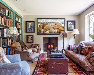 How to design a living room color palette with green bookshelves, blue and brown armchairs and red patterned rug and armchair.